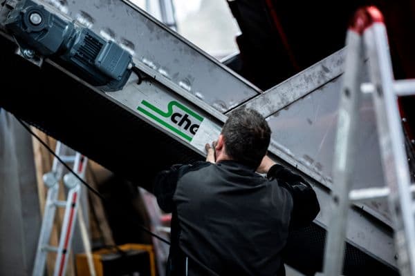 Mitarbeiter beklebt Elevator mit Scherfler Logo